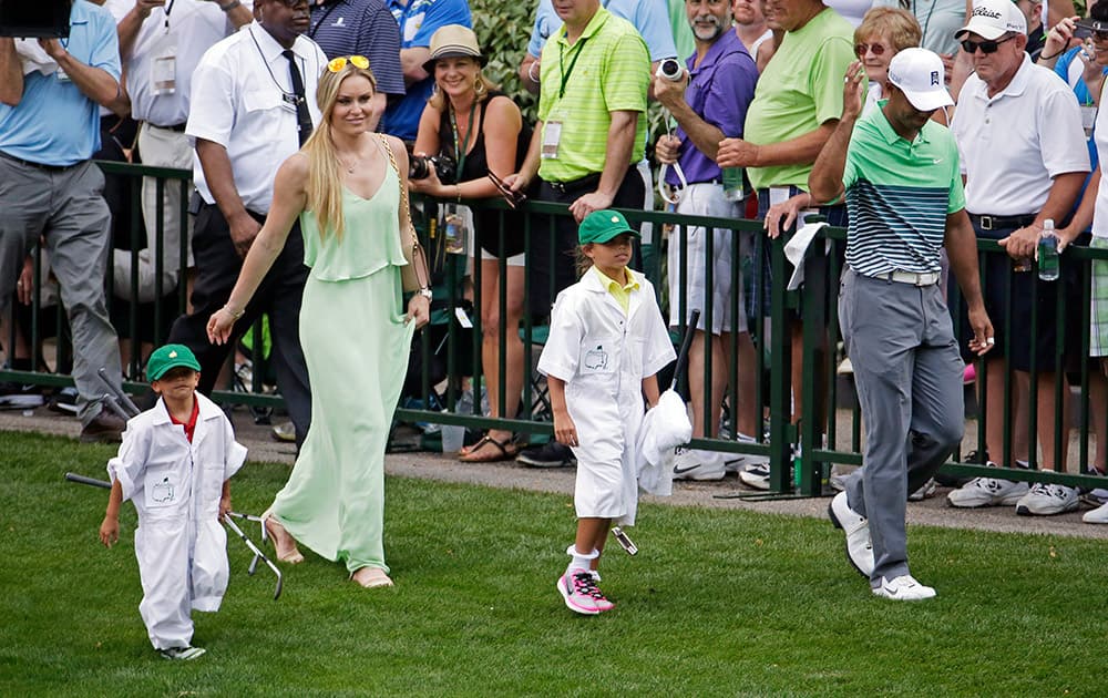 Lindsey Vonn walk Tiger Woods and his children Sam and Charlie during the Par 3 contest at the Masters golf tournament, in Augusta, Ga. 