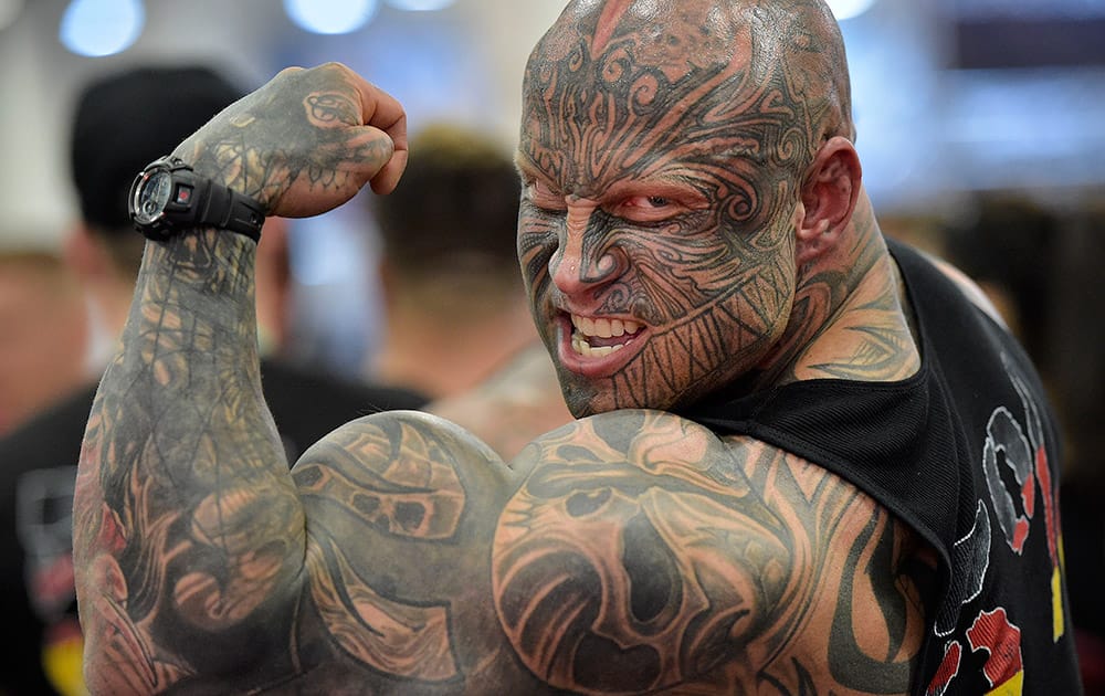 Bodybuilder Jens Dalsgaard from Denmark shows his muscles to visitors at the FIBO Power, a bodybuilding fair in Cologne, Germany.