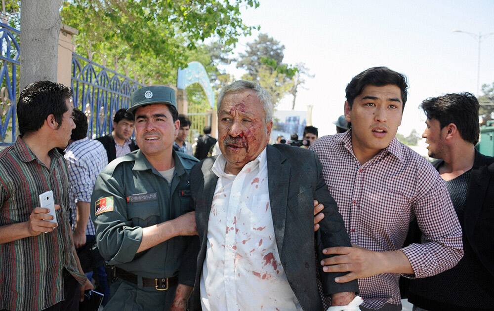 A wounded man is assisted after gunmen stormed a government compound in Mazar-e-sharif, north of Kabul, Afghanistan.