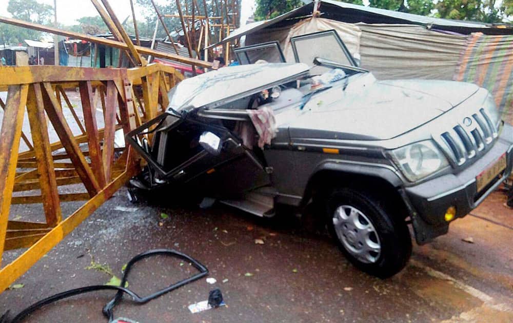 A car is crushed under a heavy lifting crane that fell down due to thunder storm and rains in Amarkantak, Madhya Pradesh.
