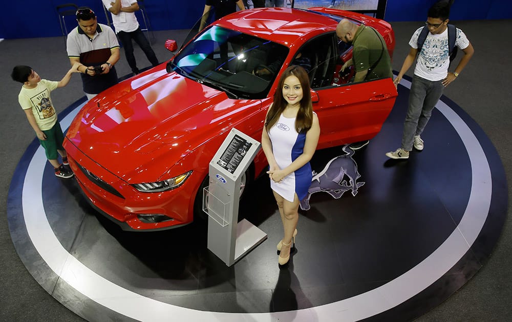 Visitors check the all-new Ford Mustang sports car during the Manila International Auto Show at the World Trade Center in suburban Pasay city, south of Manila, Philippines. 