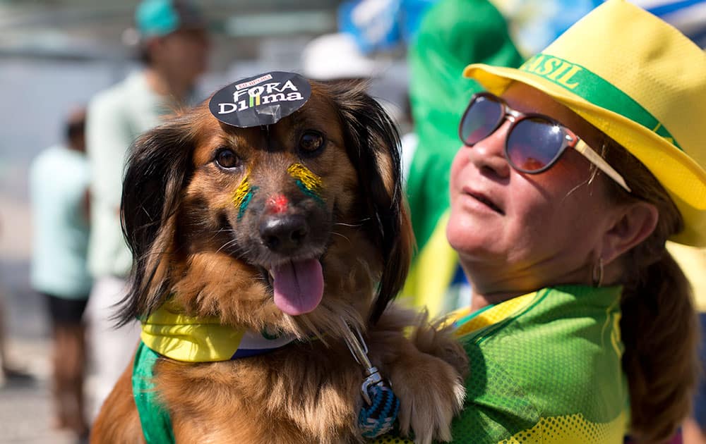 A woman carries her dog 