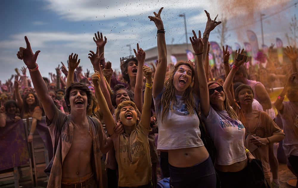 Revelers, covered in coloured powder, celebrate, during a Holi Run Festival in Madrid, Spain. Thousands of revelers took part in the festival that includes a mini marathon. 