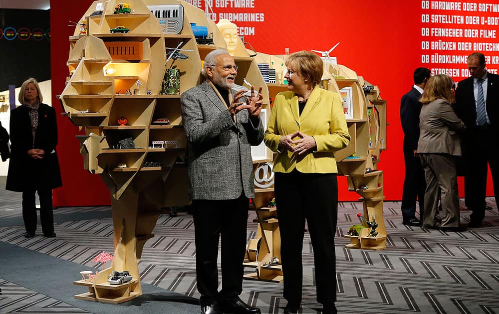 German Chancellor Angela Merkel and India's Prime Minister Narendra Modi, chat at the India booth during the opening of the industrial fair in Hanover, Germany.