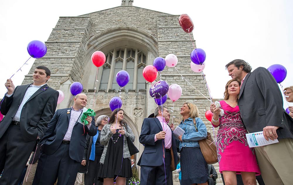 Attendees gather after a memorial mass, at St. Peter's Parish in Kansas City, Mo., to release balloons in honor of shooting victims Terri LaManno, Reat Underwood and William Corporon. Monday marked the anniversary of the shootings that killed the three victims outside Jewish facilities in Overland Park.