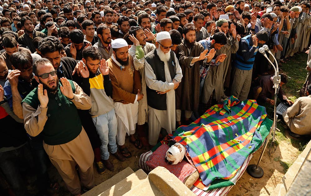 Kashmiri Muslim villagers pray by the body of Khaled Muzaffar, a civilian during his funeral procession in Tral, some 38 Kilometers (24 miles) south of Srinagar.