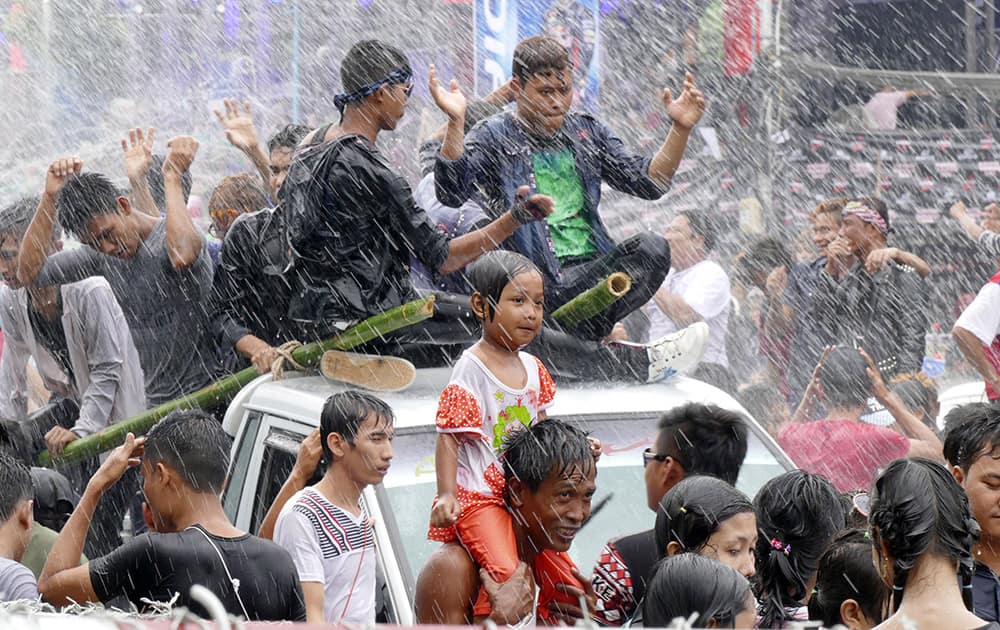 Merrymakers dance on a truck as they are sprayed with water during the annual Thingyan water festival celebrations in Yangon, Myanmar. 