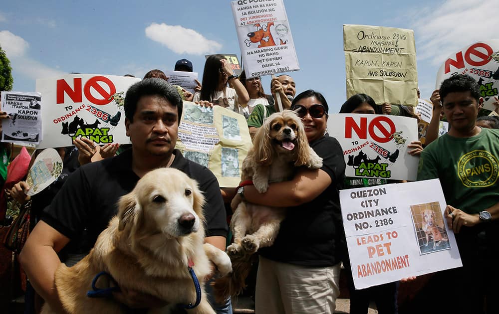 With their pets in tow, animal welfare advocates gather at the Quezon city hall to protest the new city ordinance limiting the number of pets for every household to four in the city northeast of Manila, Philippines.