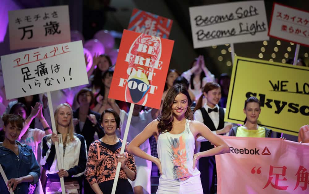 Australian model Miranda Kerr, poses with other women participants during a promotional event for Reebok's Skyscape women's shoes in Tokyo.