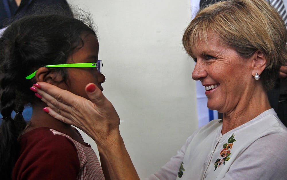 Australian Foreign Minister Julie Bishop interacts with an Indian school child at an event to provide free glasses to them as part of an Australian aid program in Chennai.