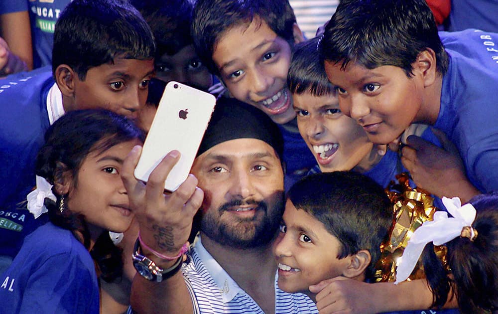 Mumbai Indians player Harbhajan Singh takes a selfie with the underprivileged children at an event in Mumbai.