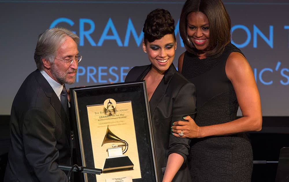 First lady Michelle Obama, along with Recording Academy President and CEO Neil Portnow, awards 15-time Grammy winner Alicia Keys the Recording Academy's Recording Artists' Coalition Award at the Grammys On The Hill Awards in Washington.