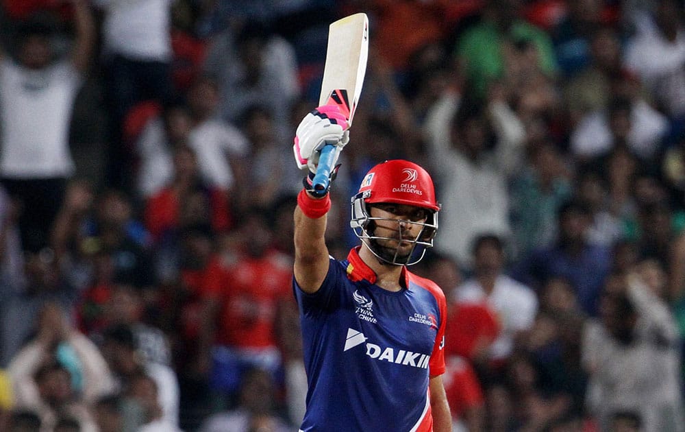 Delhi Daredevils player Yuvraj Singh raises his bat after scoring a fifty against Kings XI Punjab during an IPL T20 match in Pune.