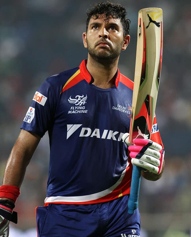 Delhi Daredevils player Yuvraj Singh raises his bat as he walks back to the pavilion after getting out during an IPL T20 match against Kings XI Punjab in Pune.