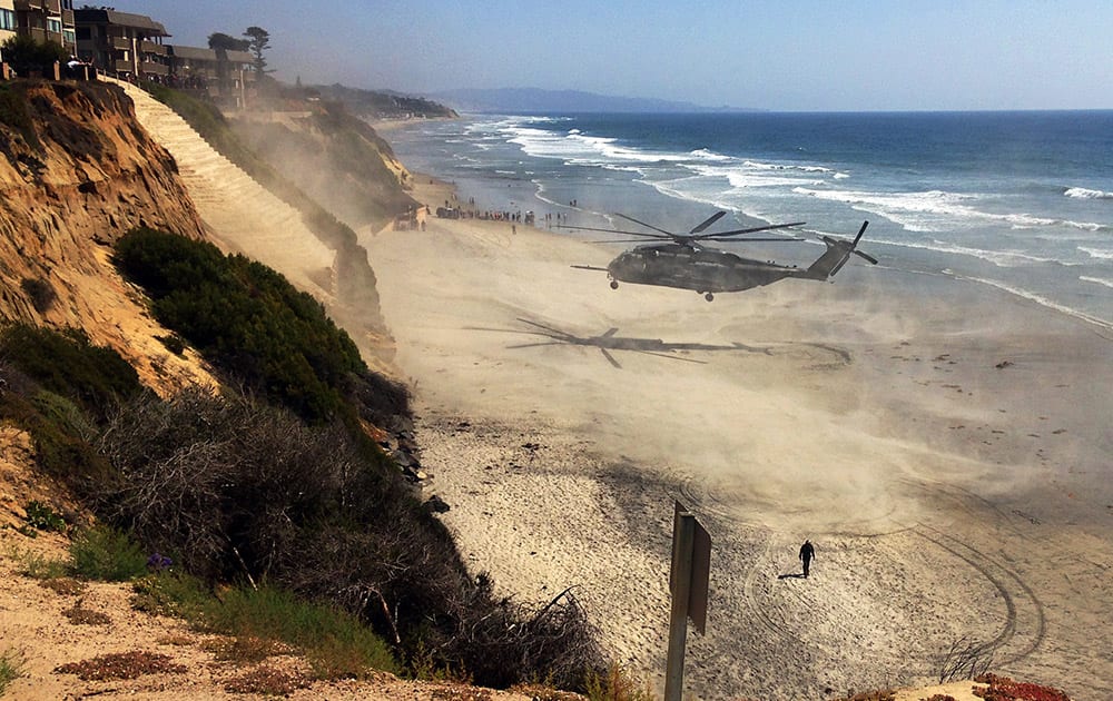 A Marine Corps helicopter lifts off from the beach after it made an emergency landing Wednesday, April 15, 2015, in Solana Beach, Calif. The helicopter landed on the shore shortly after 11:30 a.m. after a low oil-pressure indicator light went on in the cockpit, Marine Corps Air Station Miramar said in a statement.