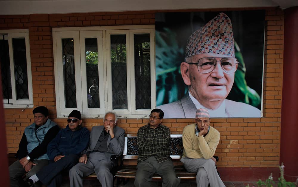 Relatives and supporters wait for the body of Nepal’s former Prime Minister Surya Bahadur Thapa, photograph behind, to arrive at his residence in Kathmandu, Nepal.