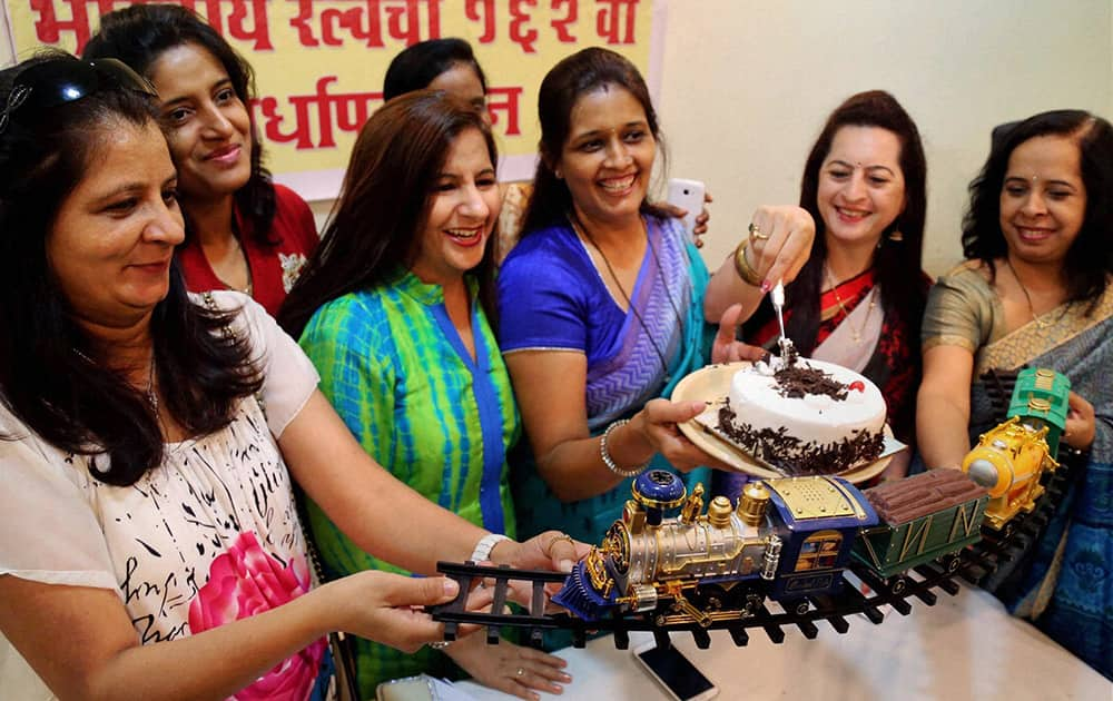 Women commuters cut a huge cake modeled on the Thane railway station on the occasion of its 162nd anniversary at Thane, Mumbai.