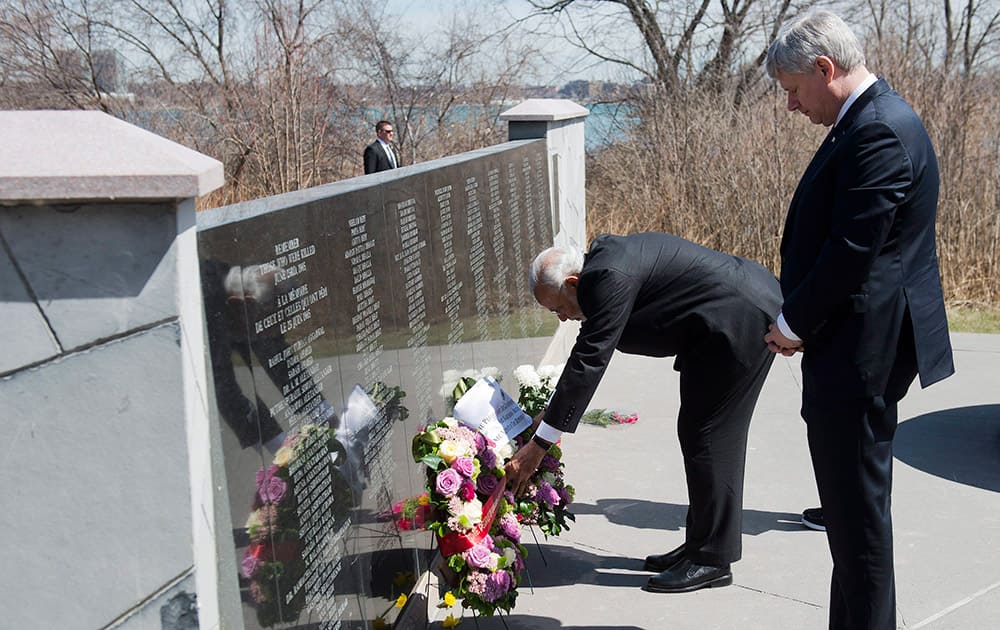 Canadian Prime Minister Stephen Harper watches Prime Minster of India Narendra Modi lay a wreath down as they visit the memorial site for victims of the 1985 Air India bombing in Toronto.