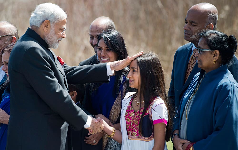 PM Narendra Modi, touches the head of a girl as they visit the memorial site for victims of the 1985 Air India in Toronto.