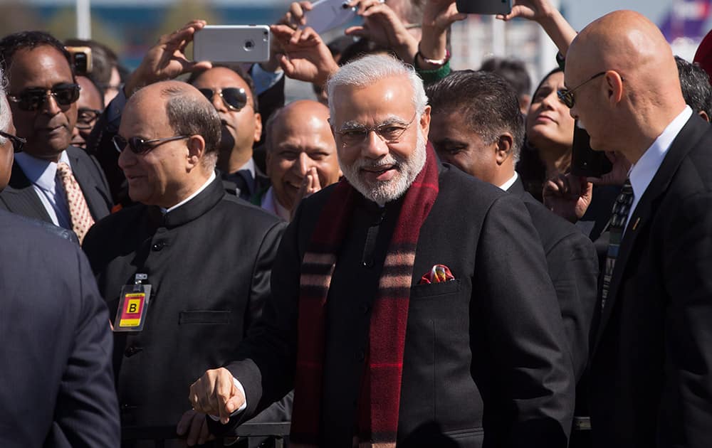 PM Narendra Modi smiles after being greeted by members of the Indian community upon arrival at Vancouver International Airport in Richmond, British Columbia.