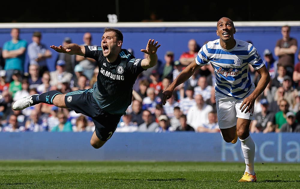 Chelsea's Branislav Ivanovic, goes airborne under a challenge from Karl Henry of QPR during the English Premier League soccer match between QPR and Chelsea at Loftus Road stadium in London.