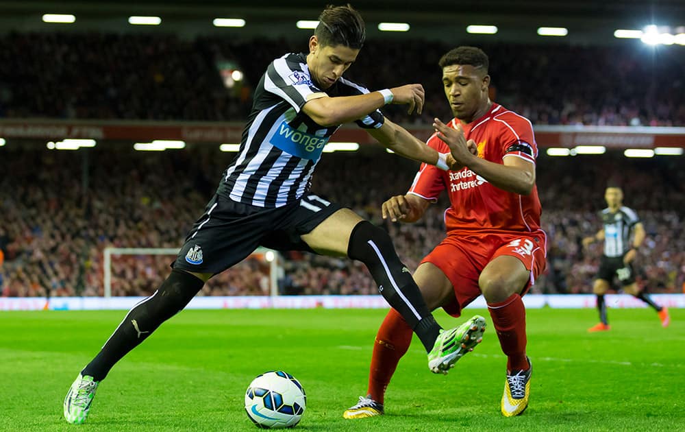 Liverpool's Jordon Ibe, attempts to block a shot by Newcastle's Ayoze Perez during the English Premier League soccer match between Liverpool and Newcastle at Anfield Stadium, Liverpool, England.