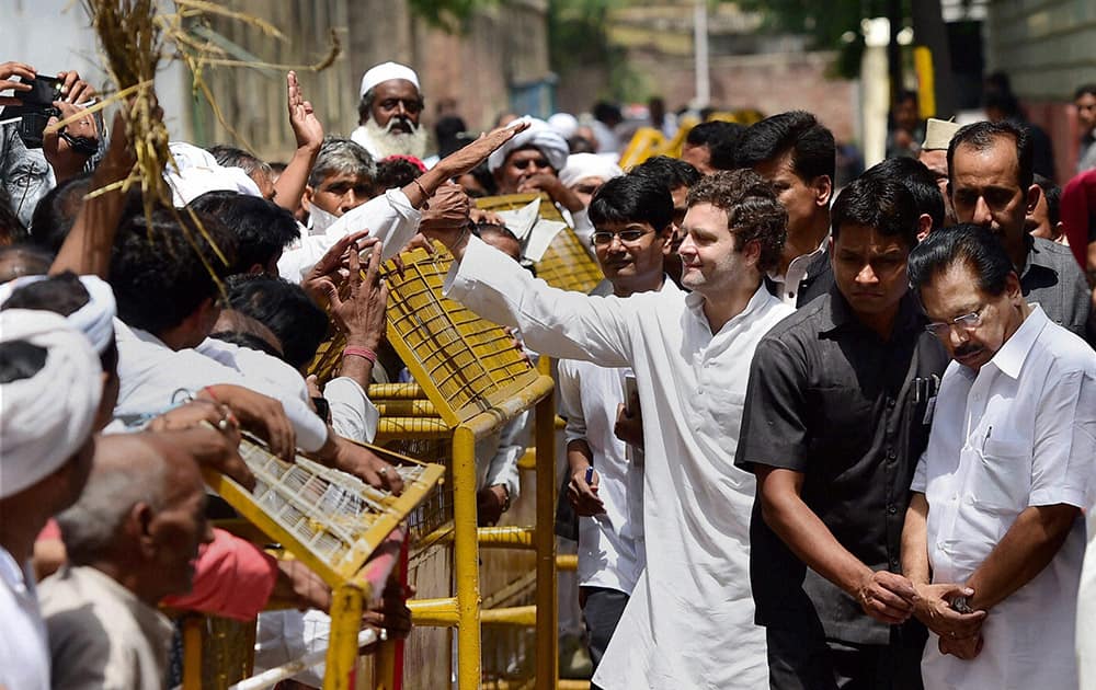 Congress Vice President Rahul Gandhi waves to the large number of farmers gathered outside his residence in New Delhi.