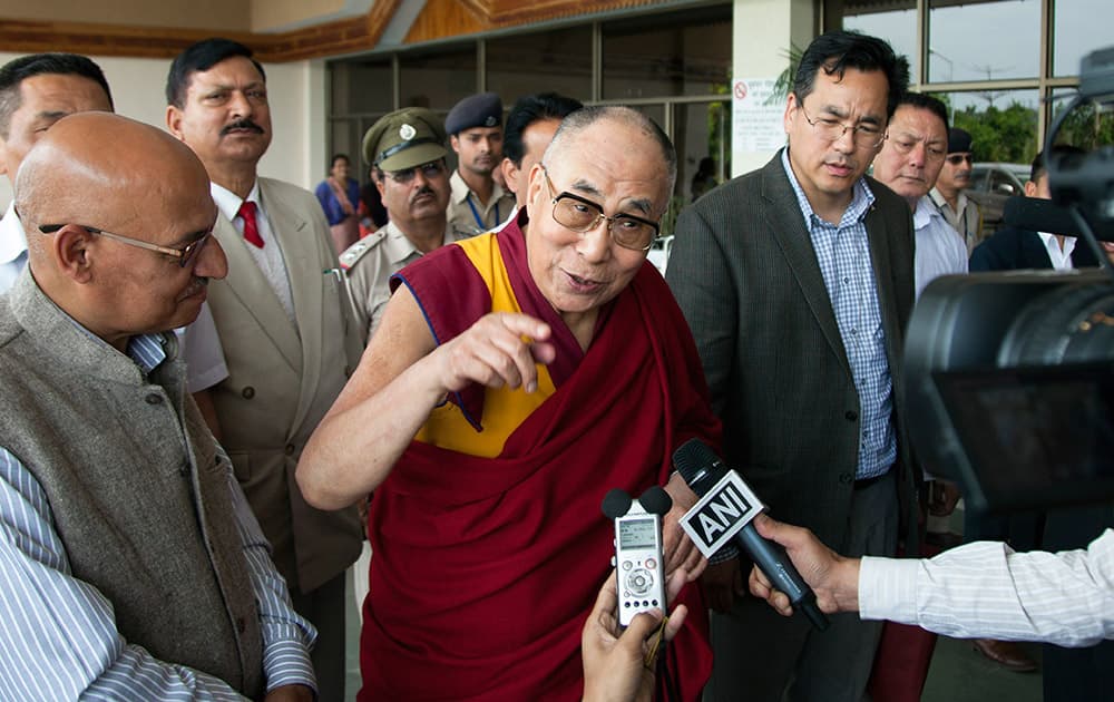 Tibetan spiritual leader the Dalai Lama speaks to the media as he arrives to receive Archbishop Desmond Tutu at Kangra airport in Dharmsala.