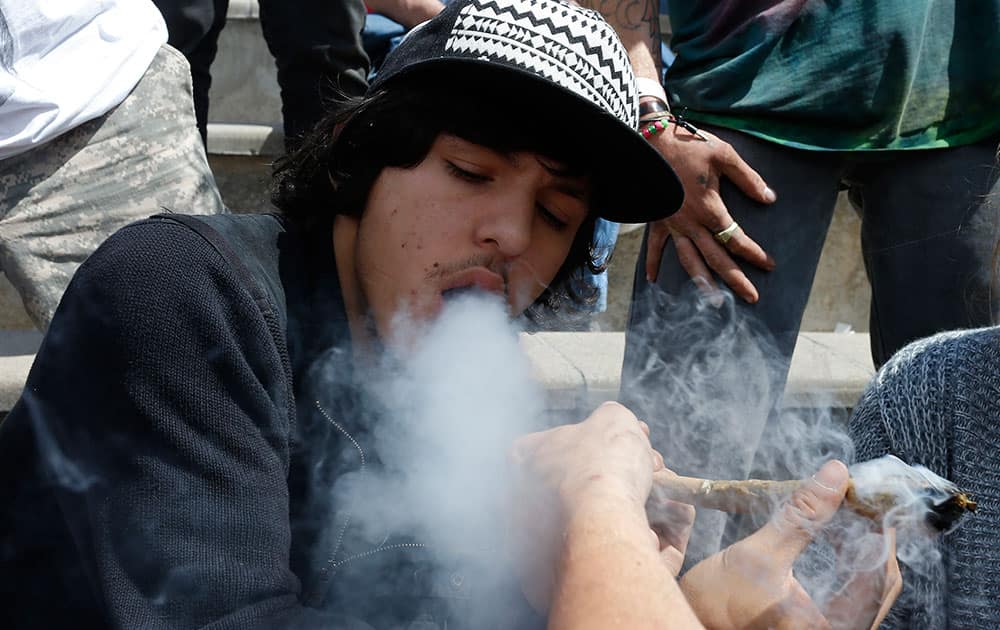 Partygoers listen to music and smoke marijuana on one of several days of the annual 4/20 marijuana festival, in Denver's downtown Civic Center Park.