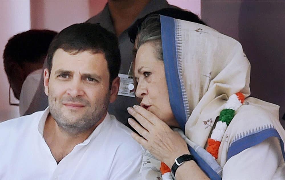  Congress President Sonia Gandhi talks to party Vice President Rahul Gandhi on stage during the farmers rally at Ramlila Maidan in New Delhi.