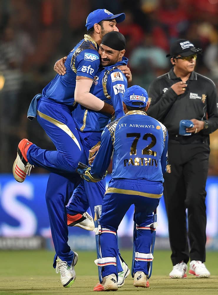 Mumbai Indians Harbhajan Singh with team mates celebrate the wicket of Chris Gayle of RCB during IPL 8 match in Bengaluru.