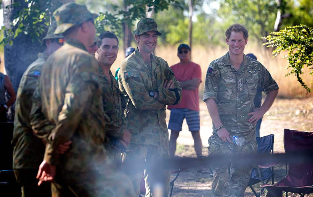 Britain's Prince Harry laughs with members of the North-West Mobile Force (NORFORCE) during a visit to the Wuggubun community in the Kununurra region, 470 kilometers (292 miles) southwest of Darwin, Australia. Capt. Wales was briefed on NORFORCE's operations and received his orders before he headed out on a patrol.