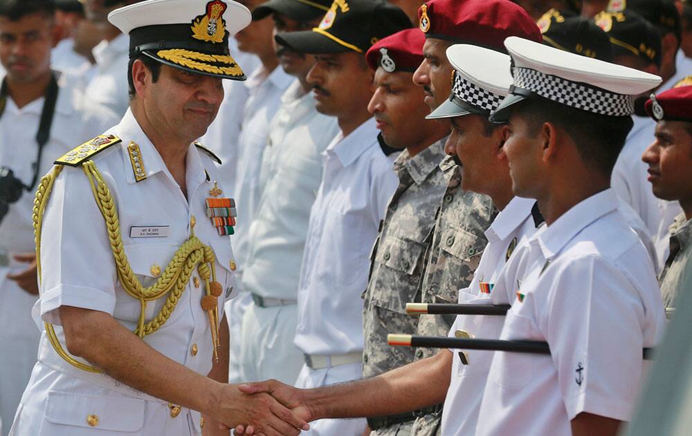 Indian Navy Chief Admiral R.K. Dhowan shakes hands with members of the Operation Rahat team onboard Indian stealth frigate INS Tarkash at the naval dockyard in Mumbai, India.