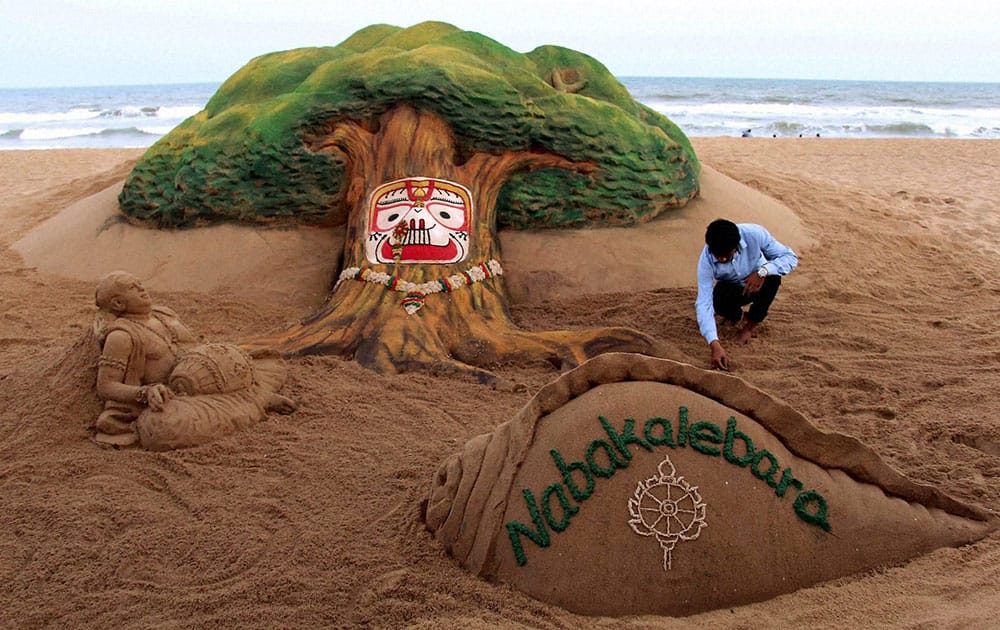 Sand artist Sudarsan Pattnaik creates a sand sculpture on Nabakalebara at Puri beach of Odisha.