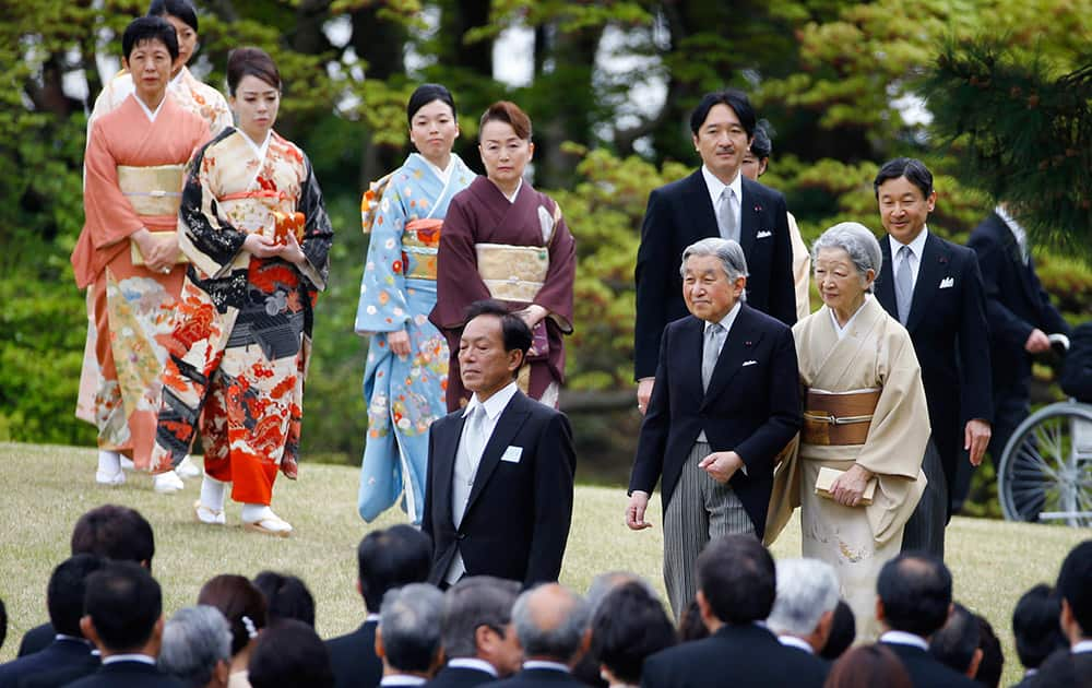 Japan's Emperor Akihito, Empress Michiko, Crown Prince Naruhito, Prince Akishino and other royal family members walk down a hill to greet guests during the spring garden party at the Akasaka Palace imperial garden in Tokyo.