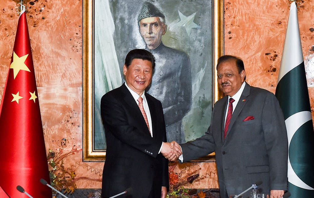 This photo released by China's Xinhua News Agency, Chinese President Xi Jinping, shakes hands with his Pakistani counterpart Mamnoon Hussain in Islamabad, Pakistan.