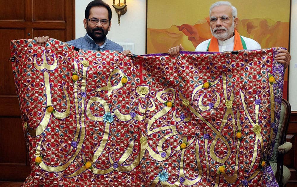 Prime Minister Narendra Modi handing over to the Minister of State for Minority Affairs and Parliamentary Affairs, Mukhtar Abbas Naqvi a Chadar, to be offered at the shrine of Khwaja Moinuddin Chishti, in New Delhi.