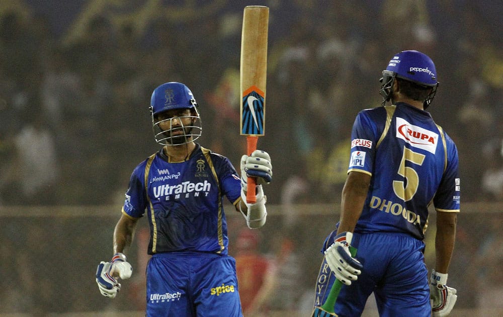 Rajasthan Royals player Ajinkya Rahane raises his bat after scoring a fifty during their IPL T20 match against Kings XI Punjab at the Sardar Patel Stadium in Ahmedabad.