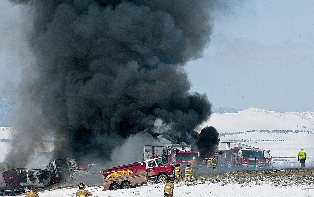 Smoke rises as emergency personnel respond to a a fiery chain-reaction crash on Interstate 80 near Laramie, Wyo.