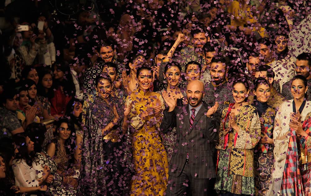 Models celebrating the PFDC Sunsilk Fashion Week Spring/Summer 2015 with a designer, in Lahore, Pakistan.