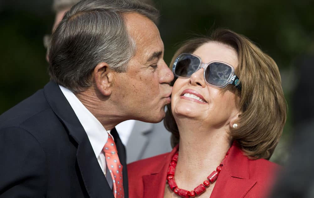 House Speaker John Boehner of Ohio, left, kisses House Minority Leader Nancy Pelosi of Calif., right, in the Rose Garden of the White House before President Barack Obama's remarks to members of Congress.