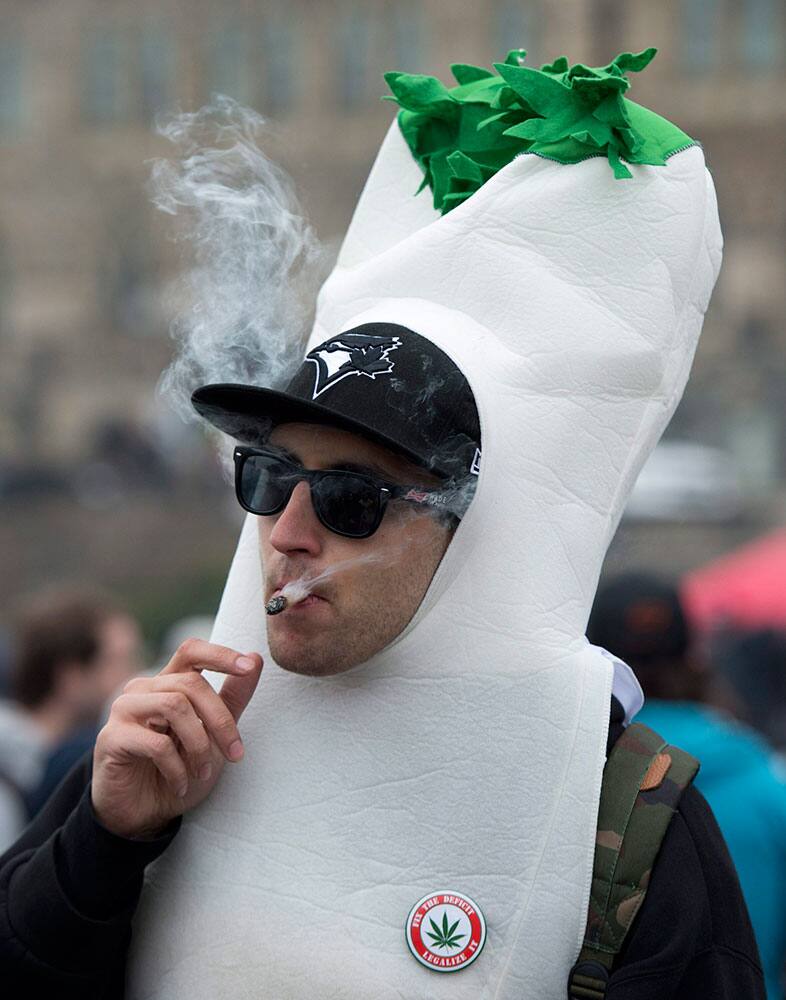 A man dressed in a marijuana joint costume smokes a joint during a 4/20 protest on Parliament Hill, in Ottawa, Ontario. 