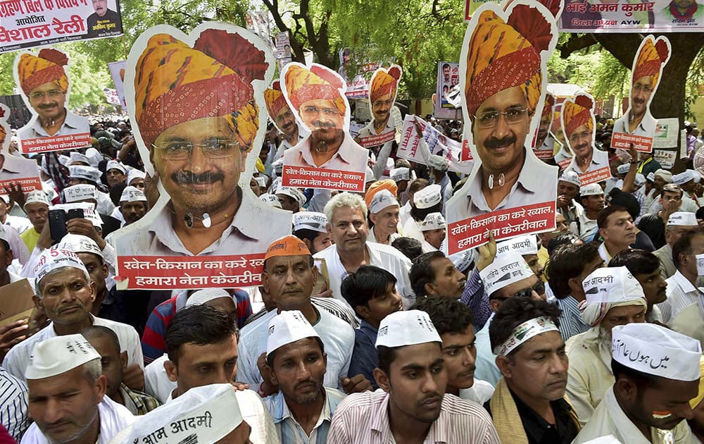Supporters wave Delhi CM Arvind Kejriwals posters during Aam Aadmi Party (AAP)s rally against the Union governments Land Acquisition Bill at Jantar Mantar in New Delhi.