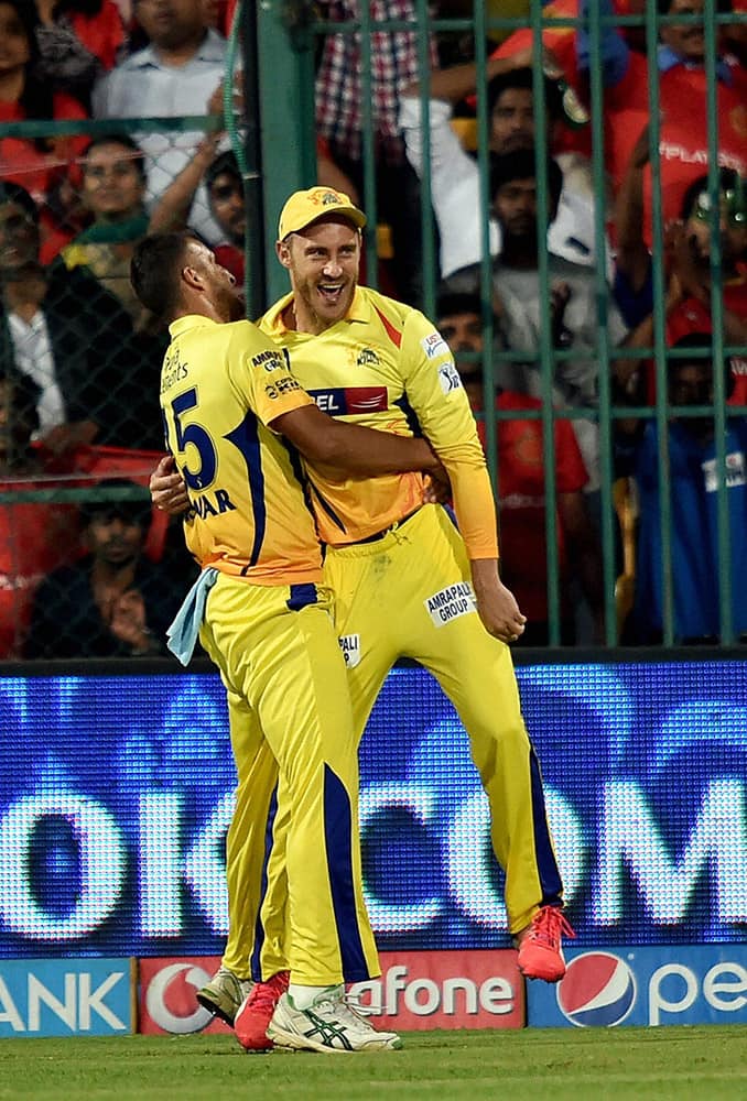 Chennai Super Kings Faf Du Plesis with Suresh Raina after taking a sucessful catch of Manvender Bisla during IPL 8 against Royal Challengers Bangalore match at Bengaluru.