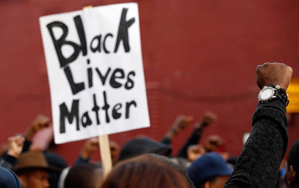 Marchers raise their fists in the air near the Baltimore Police Department's Western District police station during a march for Freddie Gray, in Baltimore. 