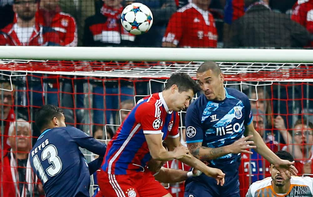 Porto's Diego Reyes, Bayern's Robert Lewandowski and Porto's Maicon Roque, from left, go for a header during the soccer Champions League quarterfinal second leg match between Bayern Munich and FC Porto at the Allianz Arena in Munich, southern Germany.