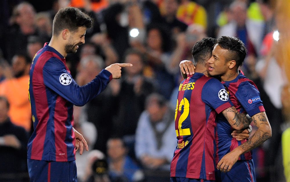 Barcelona's Gerard Pique, left, points at teammate Neymar after he scored the opening goal during the Champions League quarterfinal second leg soccer match between FC Barcelona and Paris Saint Germain at the Camp Nou Stadium in Barcelona, Spain.