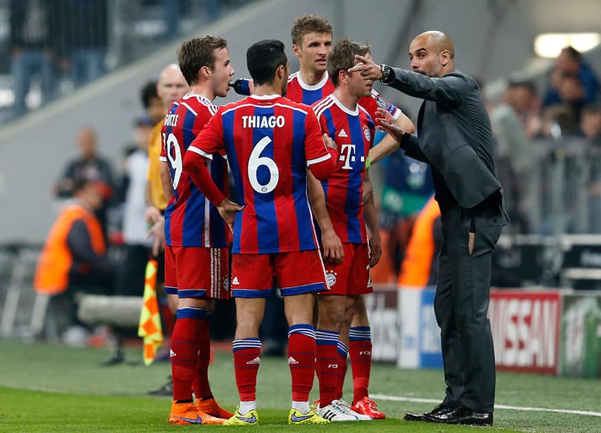 Bayern's head coach Pep Guardiola, right, instructs his players during the soccer Champions League quarterfinal second leg match between Bayern Munich and FC Porto at the Allianz Arena in Munich, southern Germany.