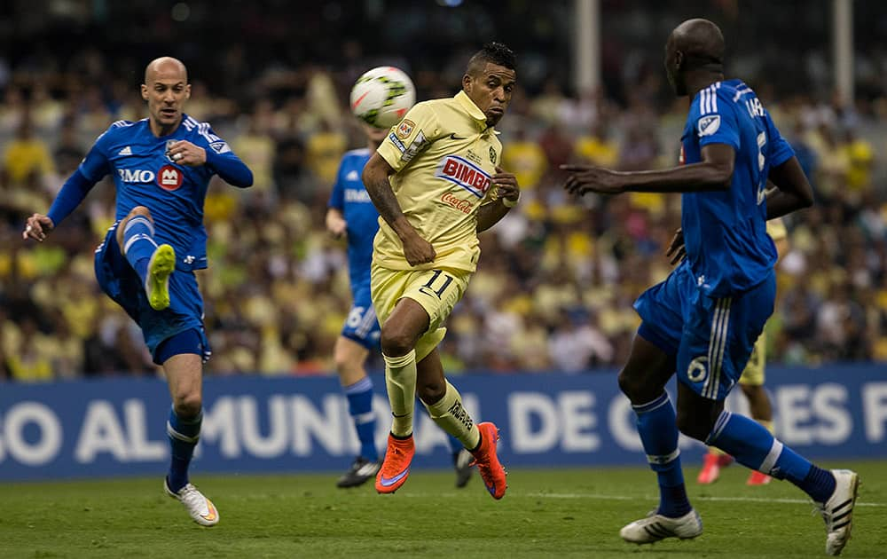 Laurent Ciman of Canada's Montreal Impact, competes for the ball with Michael Arroyo of Mexico's America, center, and Hassoun Camara of Canada's Montreal Impact during a CONCACAF Champions league match in Mexico City.