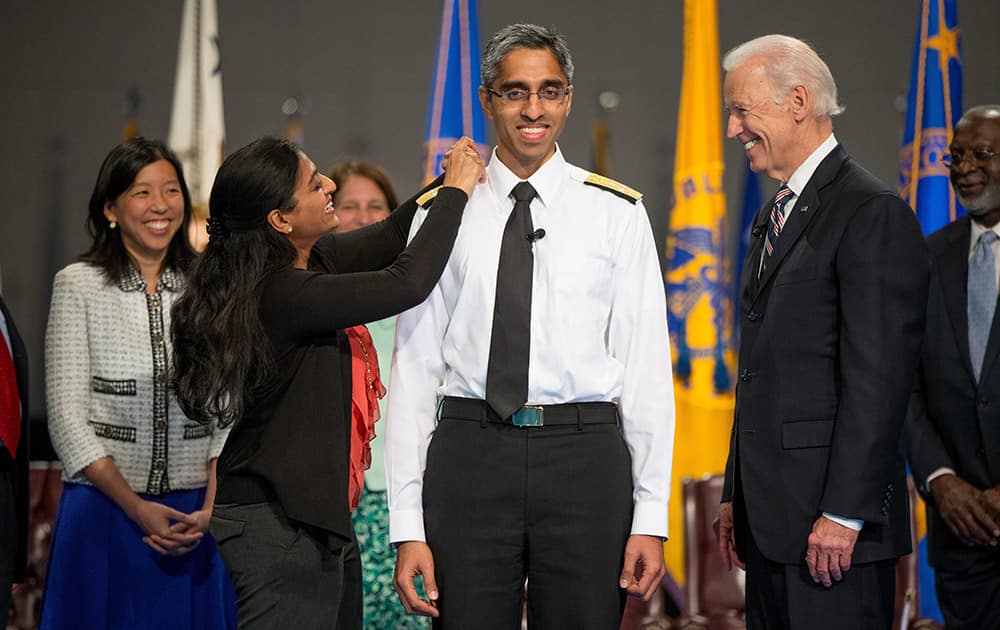 Vice President Joe Biden, watches as US Surgeon General Vivek Murthy receives an epaulet on his uniform by his sister Rashmi Murthy during a ceremonial swearing in ceremony in Conmy Hall at Fort Myer in Arlington, Va. 